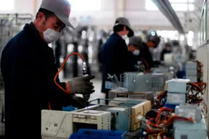 Workers sorting electronic waste at a recycling facility